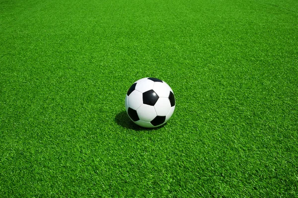 soccer ball black and white on green artificial turf