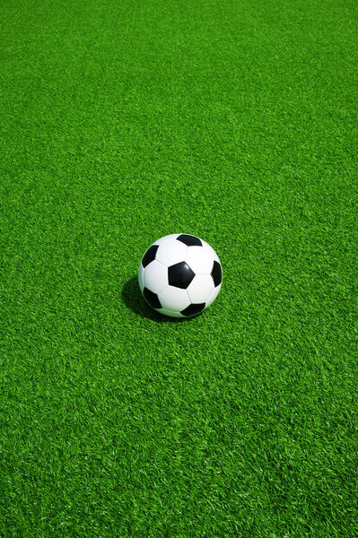 Soccer ball black and white on green artificial turf