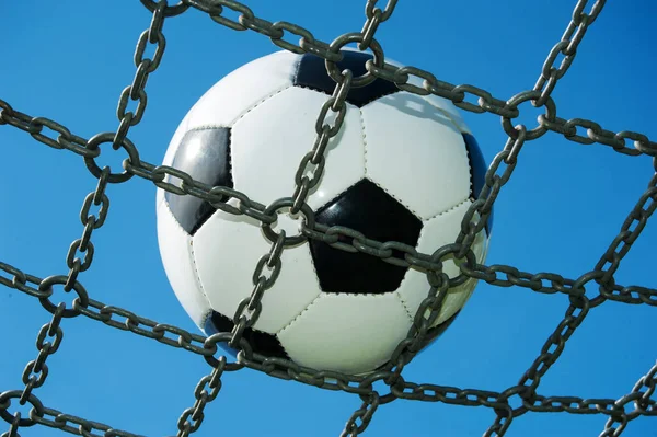 soccer ball in chain net white and black football, blue sky
