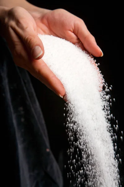 siyah arka plan üzerine düşme elinde beyaz şeker