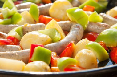 küçük sosis, patates ve domates dışında güneşte yemek sıcak bir tavada pişirme