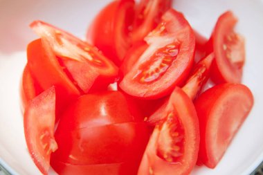 Barbekü, ham madde yemek pişirmek için hazırlanan bir kapta domates kesmek