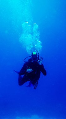 dalgıç okey işareti hava kabarcıkları ile mavi su içerisinde gösterilen