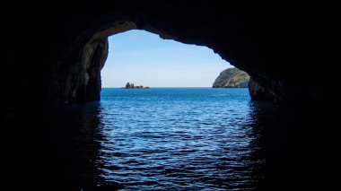 bakcground bir Isle ile okyanusta bir mağara
