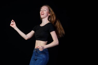 Siyah bir arka plan üzerinde kahverengi saçlı neşeli gülümseyen kız