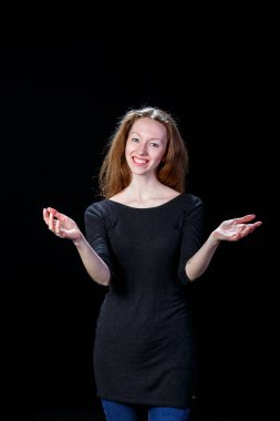 Neşeli genç kahverengi saçlı kız ellerini yanlara siyah bir zemin üzerine yayılmış