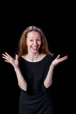 Ellerini yanlara yayılan gülümseyen neşeli genç kadın