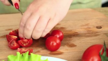Hazırlık kiraz domates ile ev yapımı sebze salatası peynir ve Bıldırcın yumurta. Eller bir kiraz domates bir bıçak ile kesmek. Kamera soldan sağa taşır.