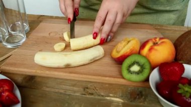 Kütük kesme tahtası muz üzerinde meyve kokteyli için çilek, şeftali. HD