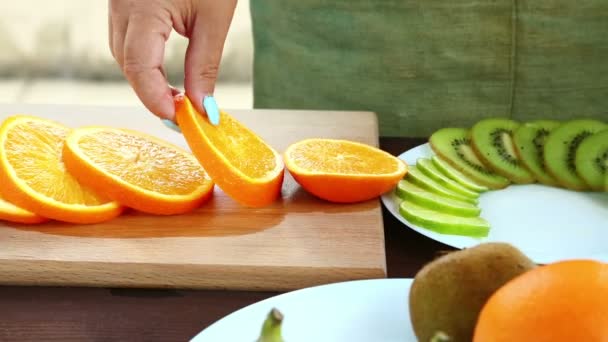 女性は オレンジ色のまな板の上にあるナイフを実行しています — ストック動画
