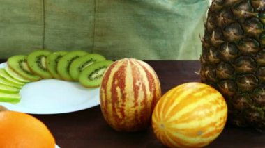 Vejetaryen diyet. Bir kesme tahtası üzerinde olan bir tabakta portakal parçaları bir kadın koyar.