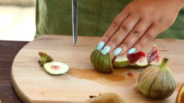 Vejetaryen diyet. Bir kadın bir bıçak bir kesme tahtası üzerinde olan incir ile çalışıyor. Full Hd Dolly ile vurdu