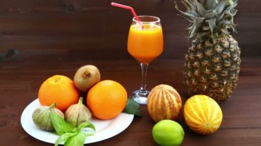 Vejetaryen diyet. Beyaz bir plaka üzerinde olan Vietnam kavun, suyu, incir, portakal, ananas.