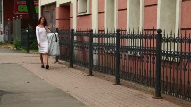 Güzel bir genç esmer kadın bir Portatif Masaj Masa omuzunda taşır..
