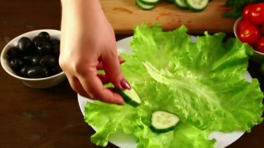 Eller adet salatalık beyaz bir tabağa koyun. Yakın çekim. Sağdan sola dolly ile vurdu