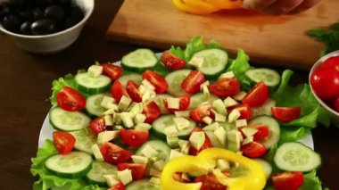 Bir kadın bir tabak sebze salata sarı biber bir parça koyar. Yakın çekim