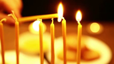 bir kadın bir mum hangi o Hanukkah mum ışıkları yardımı ile onun elinde tutar. yakın çekim. Sağdan sola doğru kamera taşımak.