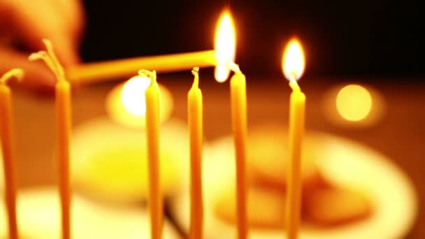 一个女人手里拿着一支蜡烛 在她的帮助下 她点燃了光明节的烛光 将相机从右向左移动 — 图库视频影像