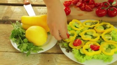 Bir kadın bir kiraz domates ile bir salata bir tabak içinde yatıyor.