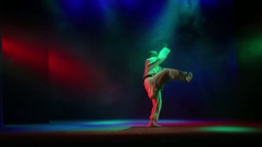 Renkli duman ile beyaz kimono arka plan giyinmiş bir karate ustası kata gerçekleştirir