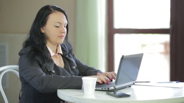 Mujer de negocios trabajando en la computadora portátil en la cafetería. Panorama de derecha a izquierda — Vídeos de Stock