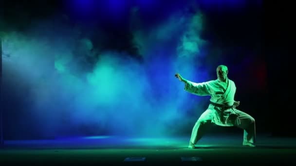 Man Betrokken Bij Karate Obdurations Tegen Achtergrond Van Gekleurde Rook — Stockvideo