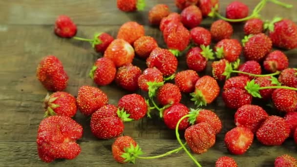Strawberries lie on a wooden table. Shooting the middle-plan outline. The camera moves to dolly from left to right. — Stock Video