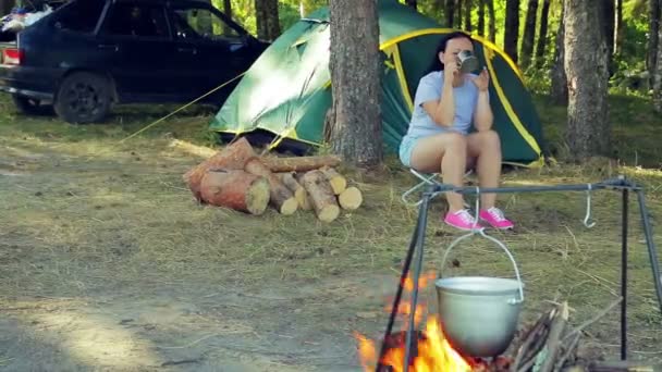 Över en brinnande eld hänger ett plommonstop. — Stockvideo