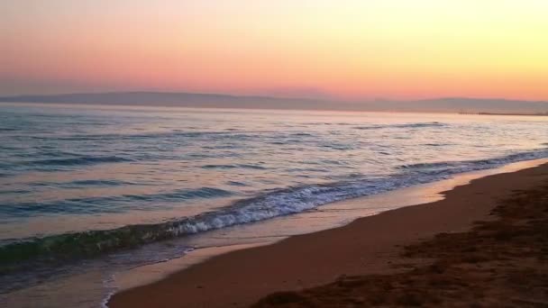 夕方の夕日を背景に砂浜のビーチと湾の波浪穏やかな 静的なカメラ — ストック動画