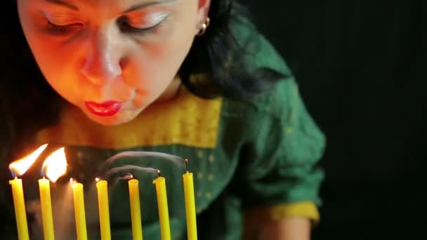 Uma mulher sopra em velas acesas e as extingue . — Vídeo de Stock