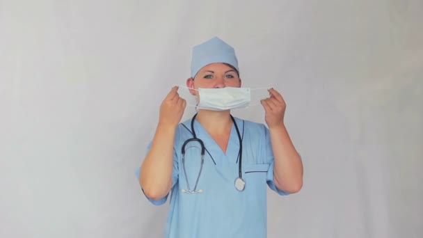 Женщина-врач одевает на себя бинт и уходит влево. . — стоковое видео