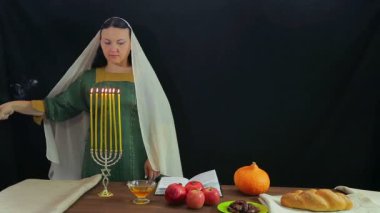 Bir Yahudi kadın onuruna Rosh Hashanah şenlikli bir mum mum ışıkları ve bir nimet okur.