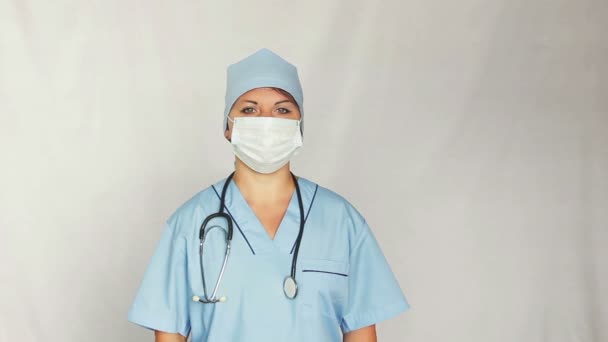 Una doctora con una bata sobre su cara mirando a la cámara. Plano medio de tiro — Vídeos de Stock