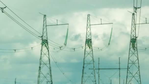 Mehrere Stromleitungsstützen befinden sich im Hintergrund von sich bewegenden Wolken. — Stockvideo