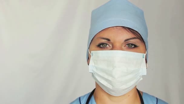 Une femme médecin avec une robe de chambre sur son visage regardant dans la caméra. La caméra se déplace vers la poupée de gauche à droite. Gros plan . — Video
