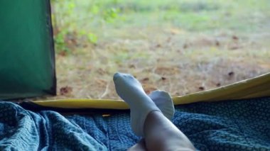 Bir kadın bir çadırda bacaklar orman manzaralı.