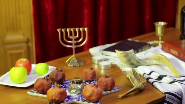 Op de tafel in de synagoge er zijn symbolen van Rosj Hasjana: behandelt, sjofar, Thora, wijn. — Stockvideo