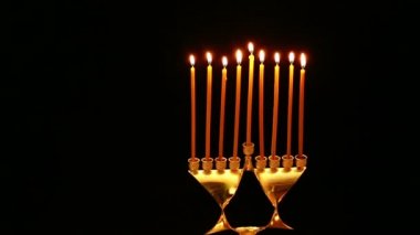 Şamdan Hanukkah için dokuz Hanukkah mum yakmak. Sağdan sola doğru kamera hareketi
