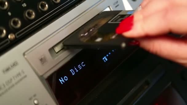 Une femme insère un mini disque dans le lecteur 