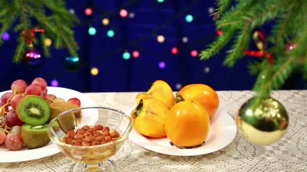 猕猴桃 葡萄和坚果与蜂蜜和在桌上用装饰的圣诞树球和灯模糊散景 — 图库视频影像