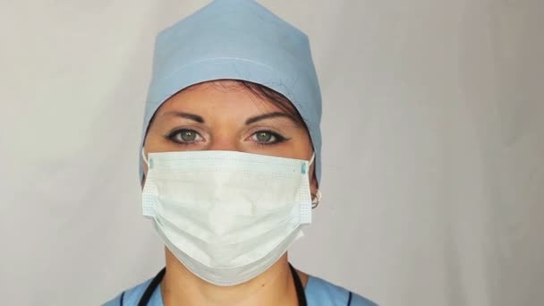 Une femme médecin avec une robe de chambre sur son visage regardant dans la caméra. La caméra se déplace vers la poupée de droite à gauche. Gros plan . — Video