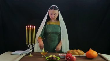 Bir Yahudi bir kadın elma bir parça bal işine dips ve çalışır.