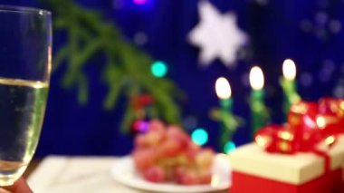 Hediyeler ve yanan mumlar ve çobanları bulanık bokeh ile bir tablonun arka planda bir şampanya ile iki gözlüklü kadın kodes gözlüklü bir adam.