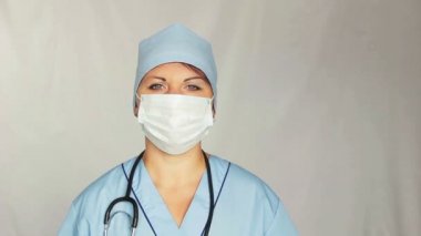 Bir sabahlık kameraya bakan yüzü üzerinde ile kadın doktor. Kamera dolly için sağdan sola taşır.