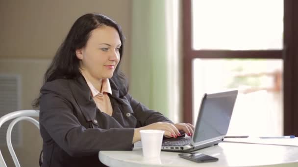 Vrouw in café die op laptop werkt. Het middelste plan schieten — Stockvideo