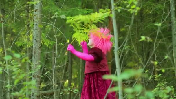 De lachende heks in het woud glade is dansen met de takken van de varens. — Stockvideo