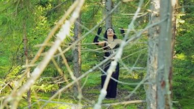 Siyah giysili bir cadı ile neşeli bir kadın ormanda törensel bir dans dans ediyor. Cadılar Bayramı. Gothick tarzı.