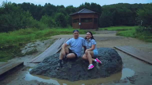 Кілька чоловіків і жінок сидять на величезному камені, виконуючи бажання . — стокове відео