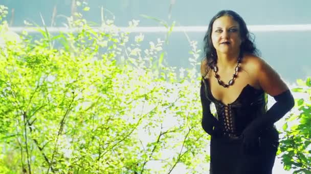 En kvinna är en häxa i svart kläder på sjön med känslor av ilska i ansiktet. Halloween. Gothick stil. — Stockvideo