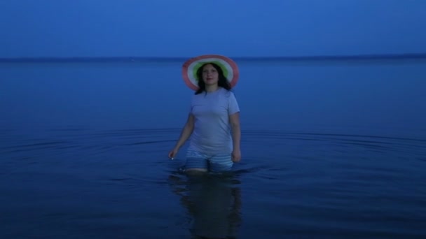 En ung kvinna går på sjön och beundrar naturen. — Stockvideo